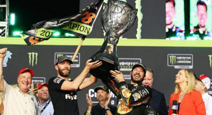 Martin Truex Jr. and crew chief Cole Pearn hoist the championship trophy after winning the title in 2017
