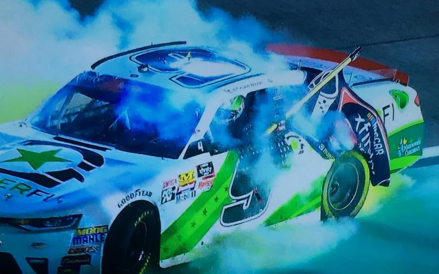 Tyler Reddick burning out with the championship flag after winning the Ford EcoBoost 300
