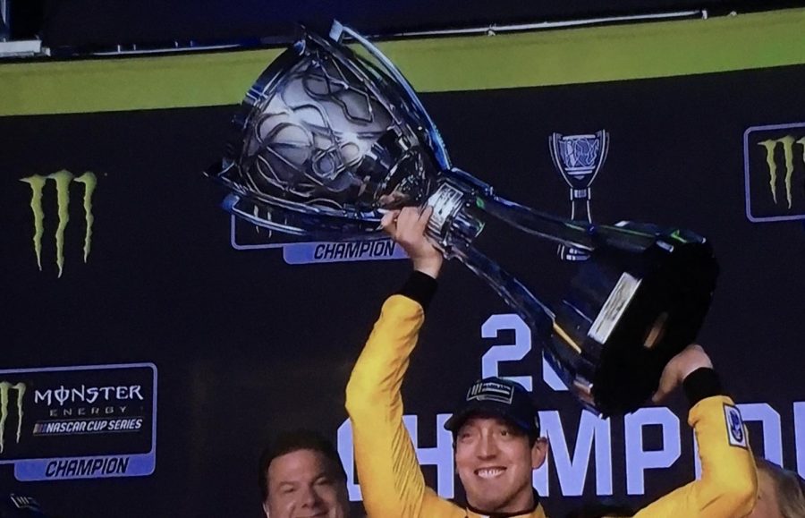 Kyle Busch hoisting the Monster Energy NASCAR Cup Series championship trophy